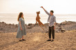 © Vasily Pindyurin/Westend61 - Young couple with dog at the beach, dog jumping