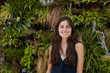 © Sullivan/Westend61 - Portrait of smiling young woman in front of plant wall