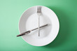 concept of intermittent fasting and ketogenic diet, weight loss. fork and knife crossed on a plate