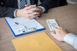 © Ngampol - Dishonest cheating in illegal money, Businessman giving bribe money the form of dollar bills to while give success the deal to contract agreement, Bribery and corruption concept