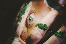 Close Up View Of Human Eye Seen Between Fingers Sprinkled With  Glitter