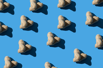 Pattern of two peanuts on a blue background. Flat lay. Minimal background texture of food nut. Creative layout