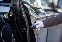 Closeup Of Chauffeur Opening Car Door With Glove.