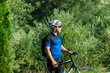 © araelf - Male cyclist standing with his bike