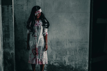 Girl zombie in the blood.The ghost of a woman stand with resentment torture and ask for help, in abandoned building, Halloween murder concept.