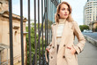 © Anton - Attractive casual blond girl in stylish trench coat confidently looking away on bridge