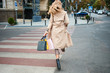 © Anton - Back view of stylish girl with shopping bags walking on pedestrian crossing