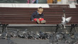 © MEDIAIMAG - Lovely baby child sit on bench and look at pigeons feeding, discover life