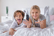 Schooler age brother and sister lying in bed and having fun at the morning