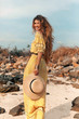 © zolotareva_elina - cheerful young stylish woman in elegant dress outdoors wearing hat havinf fun at sunset