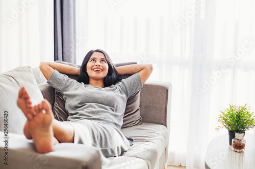Cuadros en Lienzo Pretty young asian woman relaxing on a sofa alone