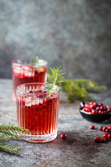 Wall Mural - Fresh cranberry cocktail with rosemary in a glass on gray background.