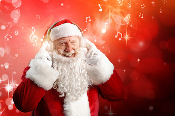 Wall Mural - Portrait of Santa Claus listening to music on dark background