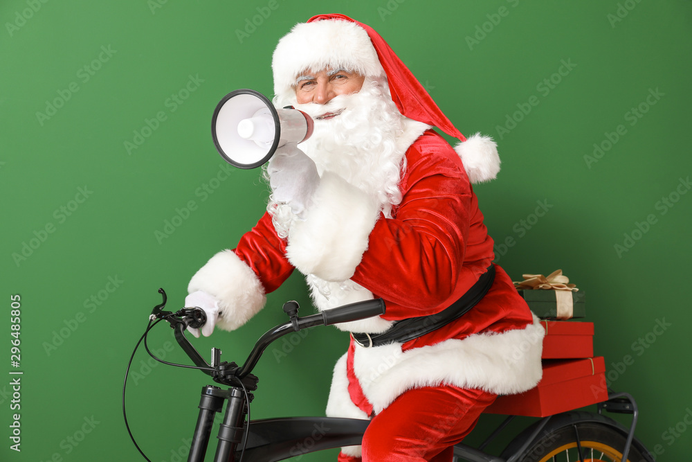 Santa Claus with megaphone and bicycle on color background