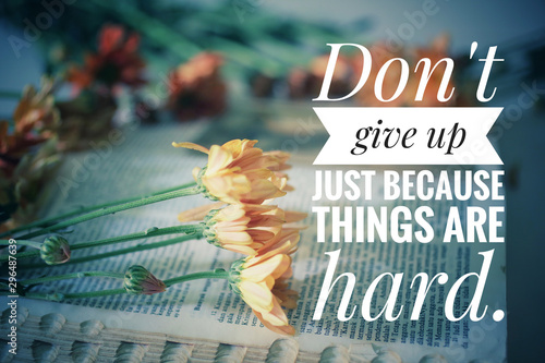 Inspirational motivational quote - Do not give up just because things are hard. With flowers on bible book background.