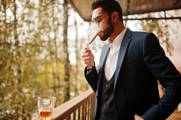 Wall Mural - Handsome well-dressed arabian man smoke cigar at balcony of pub.