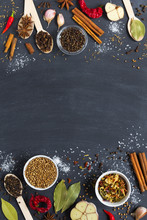 Colourful Assorted Herbs And Spices And Dry Vegetable For Cooking In Wooden Spoons And Bowls On Dark Background With Copy Space. Top View. Vertical Layout