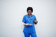 Portrait of happy female african american young doctor pediatrician in blue uniform coat and stethoscope with books at hands isolated on white.
