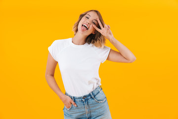 Wall Mural - Image of funny blond woman in basic t-shirt showing peace fingers