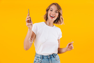 Poster - Image of cheerful blond woman listening to music with earphones