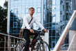 © standret - Thinks about future. Businessman in formal clothes with black bicycle is in the city