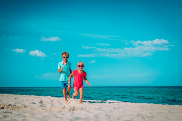 Poster - little boy and girl running on beach