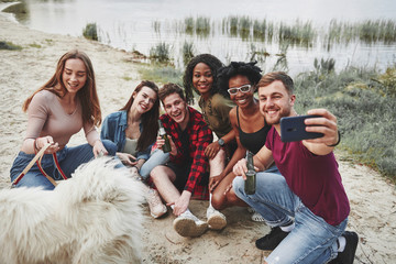 Another selfie. Group of people have picnic on the beach. Friends have fun at weekend time