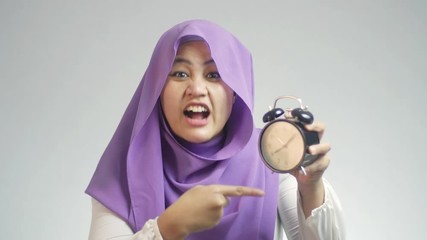 Wall Mural - Asian muslim businesswoman boss manager leader lady looked angry while showing alarm clock, time late concept