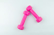 © hilalabdullah - Two pink dumbbells isolated on white background.