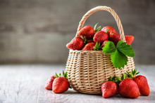 Red Strawberries In Small Wooden Basket Or Wicker. Healthy Fresh Fruits On White Table With Copy Space.