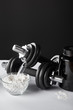 © LIGHTFIELD STUDIOS - glass bowl with protein powder near dumbbells on black