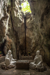 Da Nang, Vietnam »; August 2017: The white sculptures of the two wise men in the Marble Mountains of Da Nang and the outside hole above them