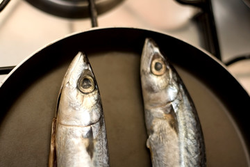 Two fish on a frying pan. Selective focus.