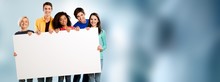 Group Of Diverse Multiethnic Happy Young People Posing With A Blank White Rectabgular Sign With Copyspace For Your Advertisement Or Text On A Grey Background