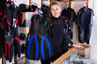 © JackF - Sporty woman is satisfied of full set diving equipment in the diving store.