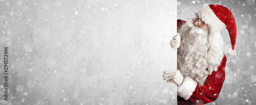 Fotomural Santa Claus Showing Something On a White Wall