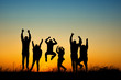 Happy people silhouette jumping in sunset
