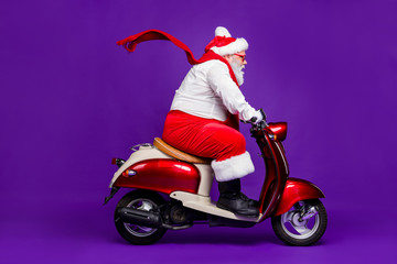 Wall Mural - Photo of fat santa man grandfather rushing speed newyear x-mas theme party by bike wear sun spectacles trousers hat suspenders isolated purple background