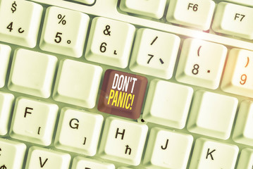 Word writing text Don T Panic. Business photo showcasing suddenly feel so worried or frightened that you can not behave White pc keyboard with empty note paper above white background key copy space