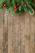 © Thidarat - Wood table plank in vertical with pine leaves and pine cones, holly balls and candy cane in Christmas theme concept. Wooden background in top view flat lay with copy space for Christmas wallpaper.