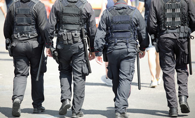 Wall Mural - four policemen of special force unit patroling the city