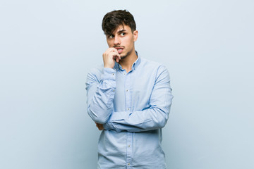 Young hispanic business man relaxed thinking about something looking at a copy space.