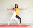 © sutlafk - Beautiful young asia woman and her charming little daughter are smiling while doing yoga together at home