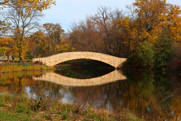 Wall Mural - beautiful fall landscape with a bridge in the city park. scenic view with colored trees and bridge i