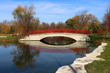 Wall Mural - beautiful fall landscape with a bridge in the city park. scenic view with colored trees and bridge i