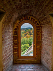  View through a window across fall colored trees in historic Gediminas tower in Vilnius Lithuania