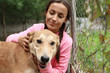 © New Africa - Female volunteer with homeless dog at animal shelter outdoors