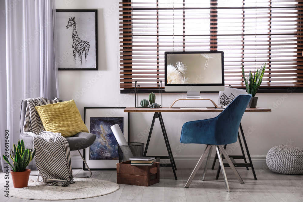 Comfortable workplace near window with horizontal blinds in room - obrazy, fototapety, plakaty 