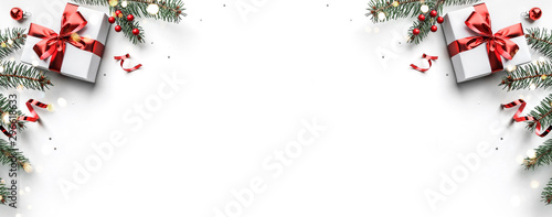 Fotografía Christmas fir branches, gift boxes with red ribbon, red decoration, sparkles and confetti on white background