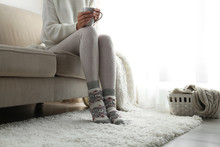 Woman Wearing Knitted Socks At Home, Closeup. Warm Clothes